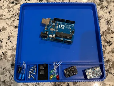 Blue 3D-printed component tray holding an Arduino and electronics parts