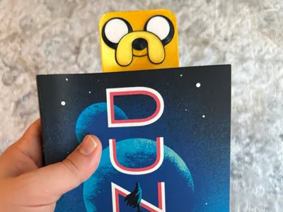 Yellow character-themed 3D-printed box behind a book
