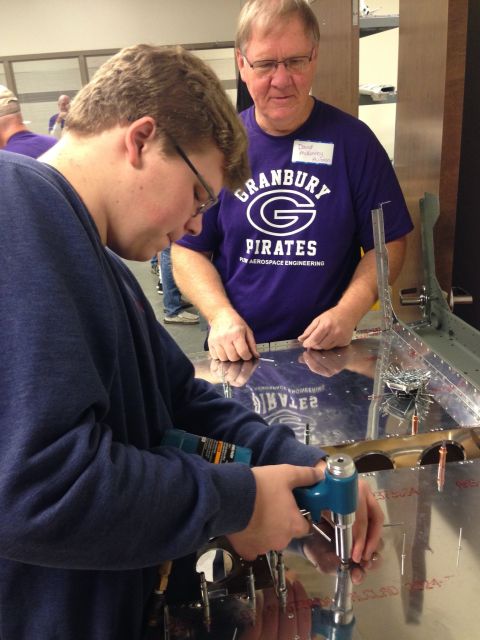 Student performing precision riveting on an aircraft panel