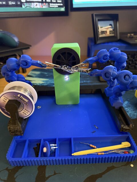 Solder-fume ventilator running between two helping hands